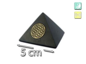 Pyramide en schungite polie ornée d’une Fleur de Vie dorée. Une alliance harmonieuse entre pierre naturelle, géométrie sacrée et élégance.