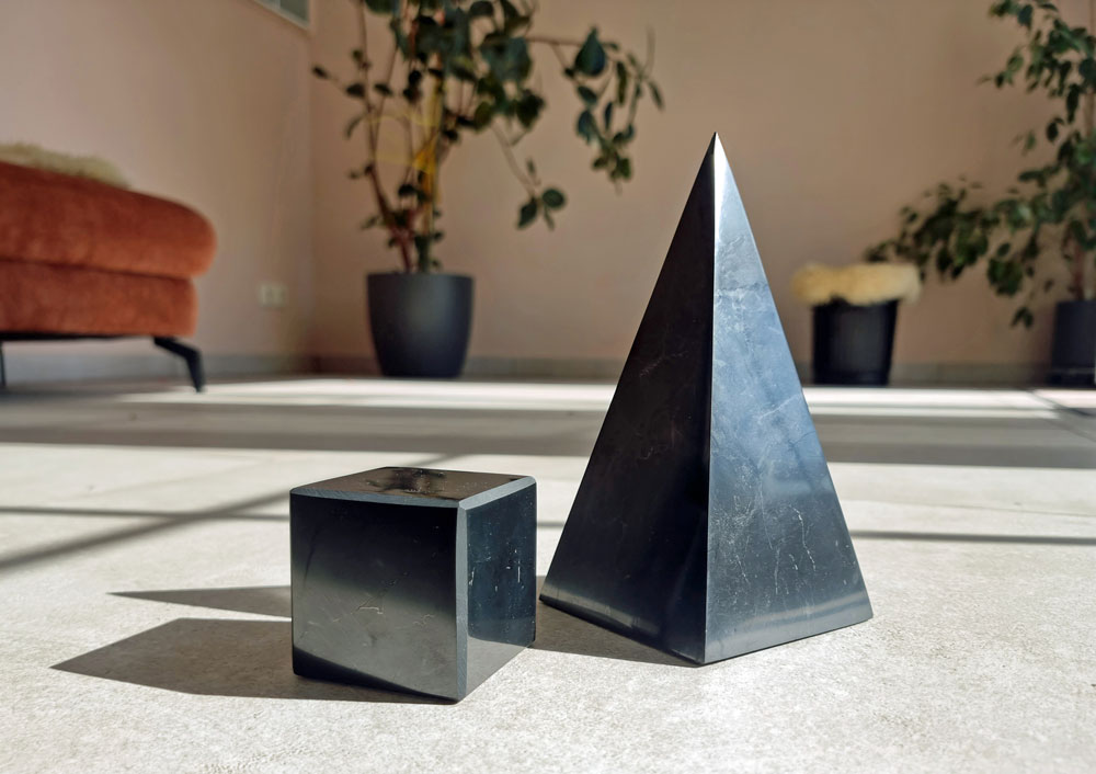 Schungit-Pyramide und -Würfel nebeneinander im Wohnbereich
