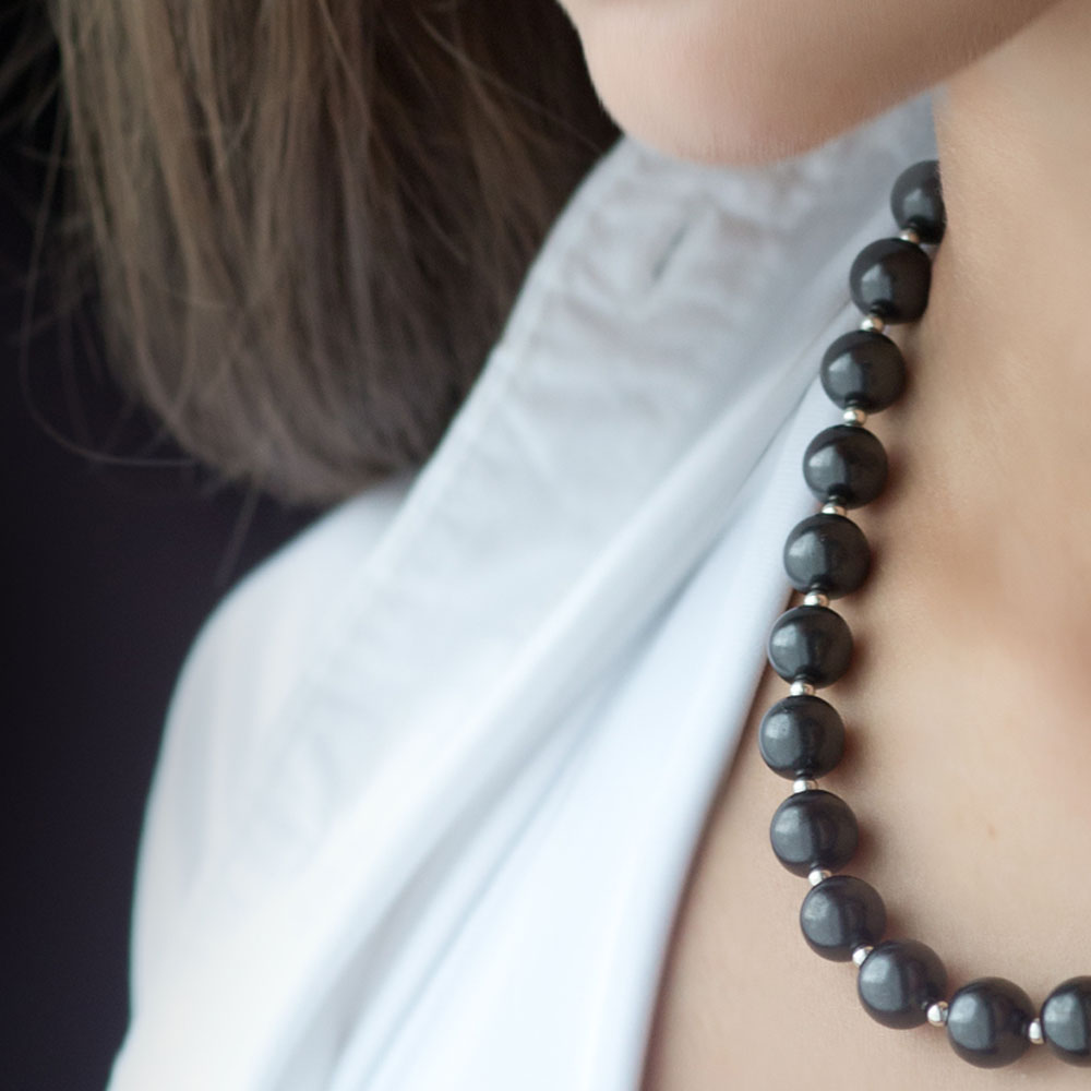 Eine elegante Schungit Kette mit runden Perlen und silberfarbenen Akzenten – stilvoller Schutz zum Tragen.