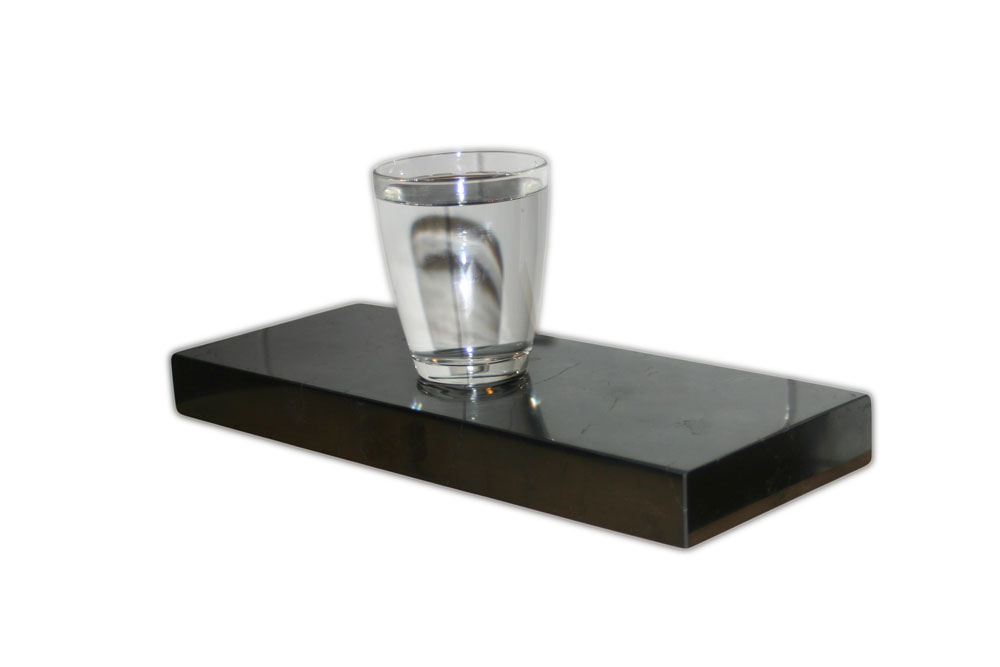 ein Glass Wasser auf eine Schungit Platte