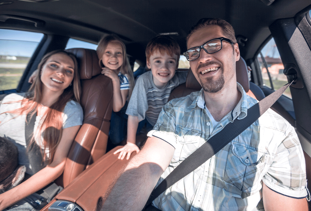 Familie mit Kindern fährt entspannt im E-Auto mit Schungit)